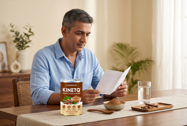 Man reading a leaflet beside a Healthibuds Arjun Chaal Powder tin, bark powder and water at home.