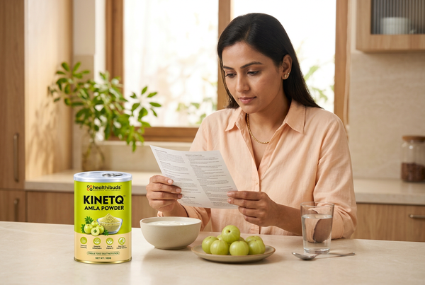 Woman reading a leaflet beside Healthibuds Amla Powder, fresh Amla, yoghurt and water in a home kitchen.