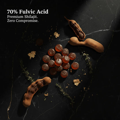 Gummy bears with tamarind pods on a dark surface, labeled '70% Fulvic Acid Premium Shilajit. Zero Compromise.'